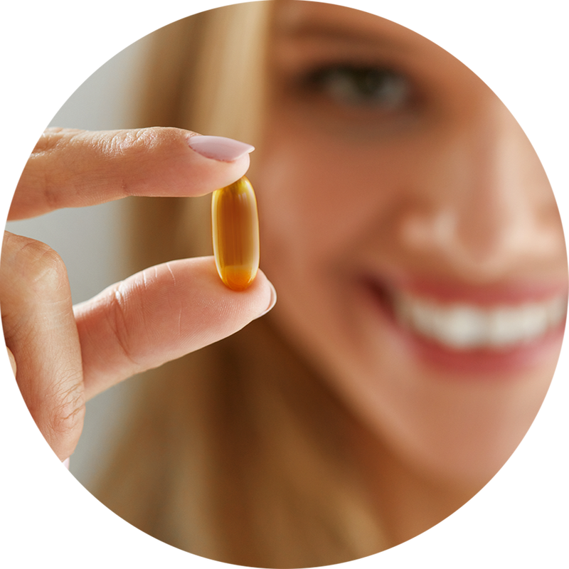 woman holding an Ovega-3 pill